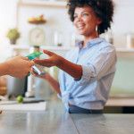 woman handing debit card to cashier