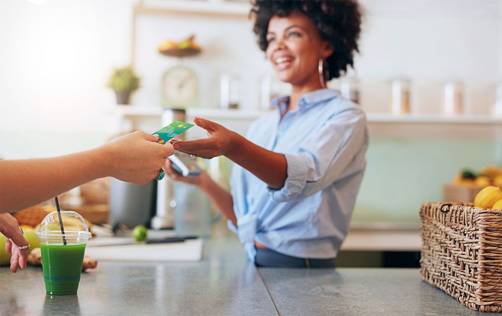 woman handing debit card to cashier