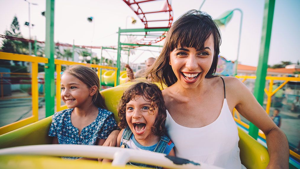 woman and kids riding rollercoaster